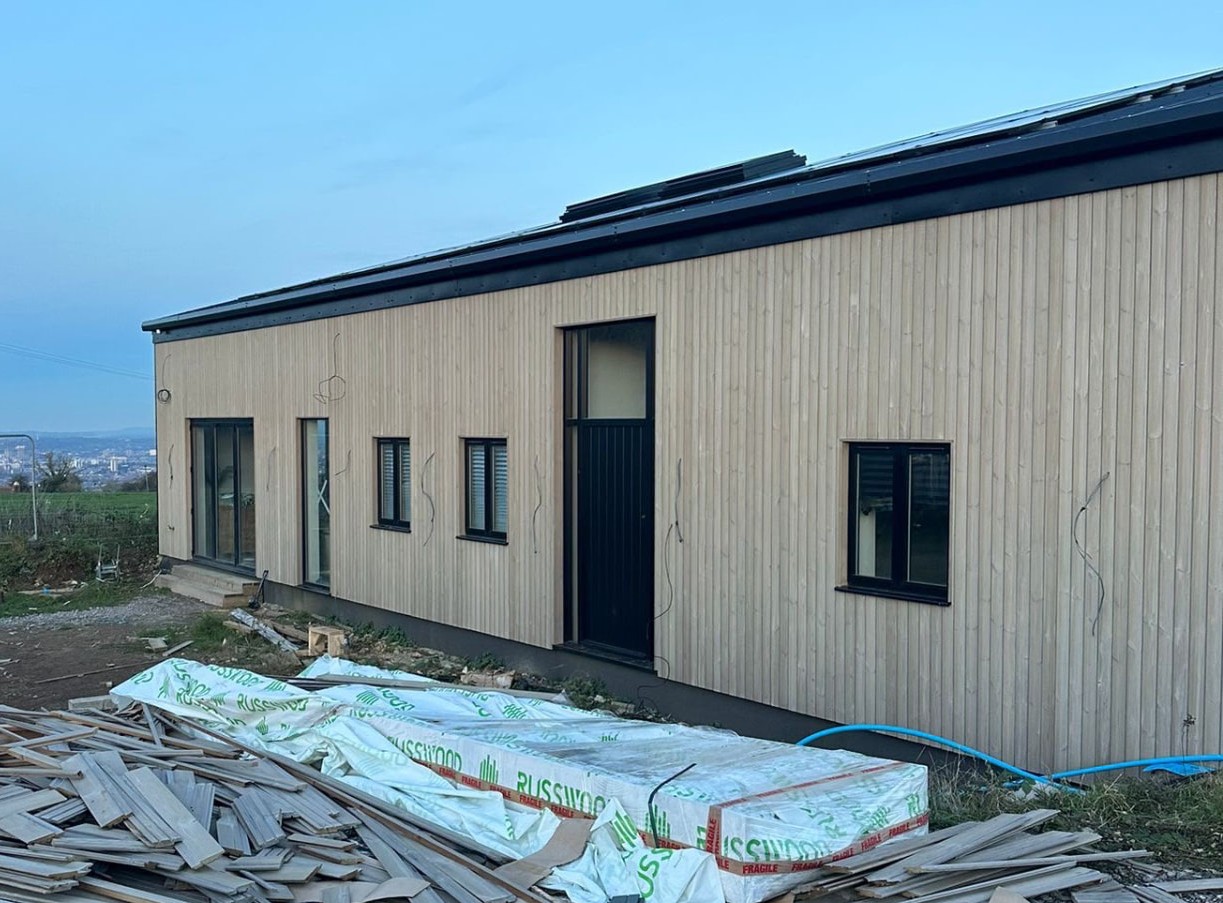 Timber frame extension with full timber cladding and roof structure